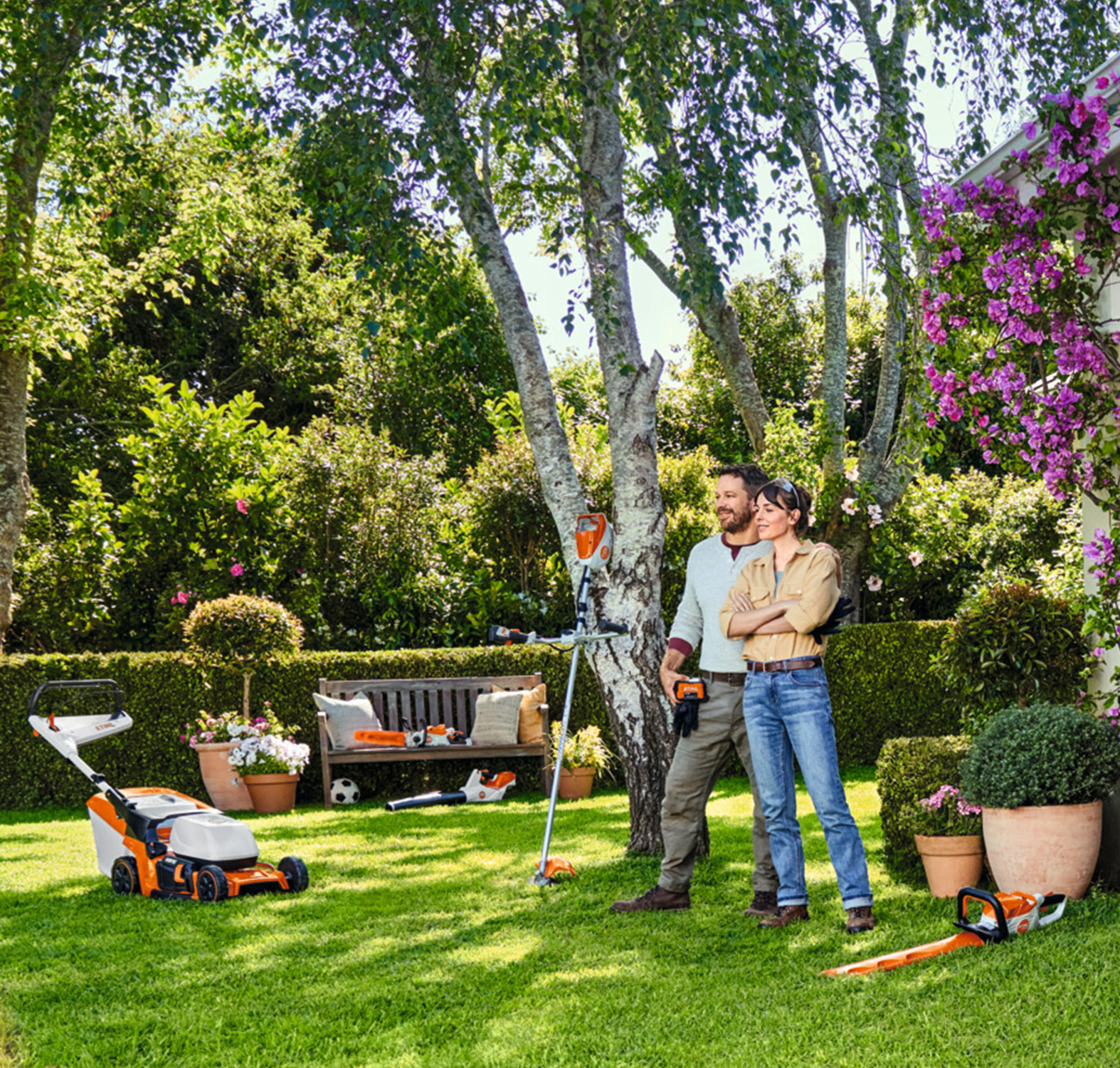 Ein Mann und eine Frau stehen in ihrem Garten und schauen stolz auf die vollbrachte Gartenarbeit