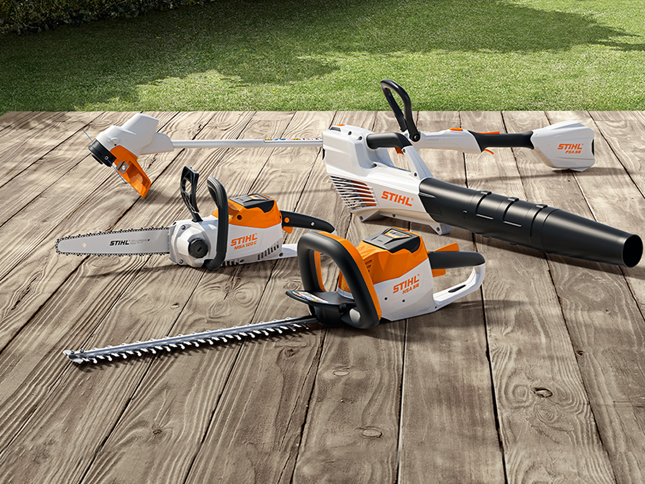 STIHL Akku-Kettensäge MSA 120 C, Akku-Rasentrimmer FSA 57, Akku-Heckenschere HSA 56, Akku-Blasgerät BGA 56 auf Holzterrasse