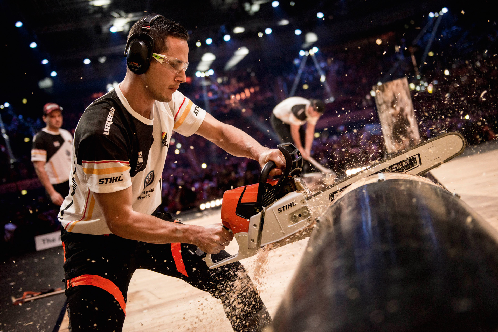 STIHL TIMBERSPORTS® Athlet sägt Baumstamm bei einem Wettbewerb 