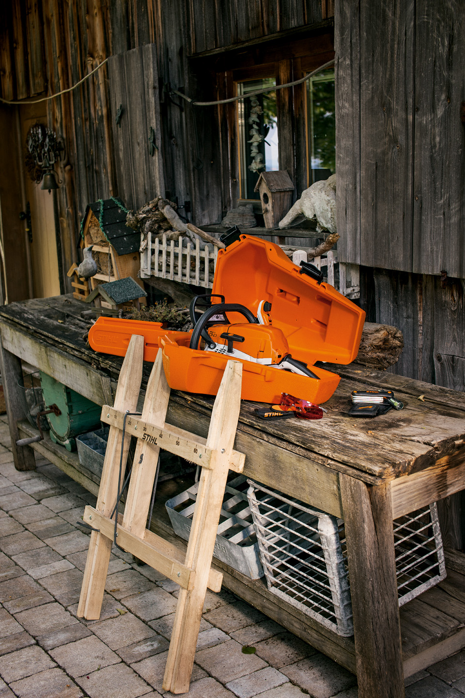 STIHL Kettensäge in Koffer zur Aufbewahrung auf einer hölzernen Werkbank neben Zubehör