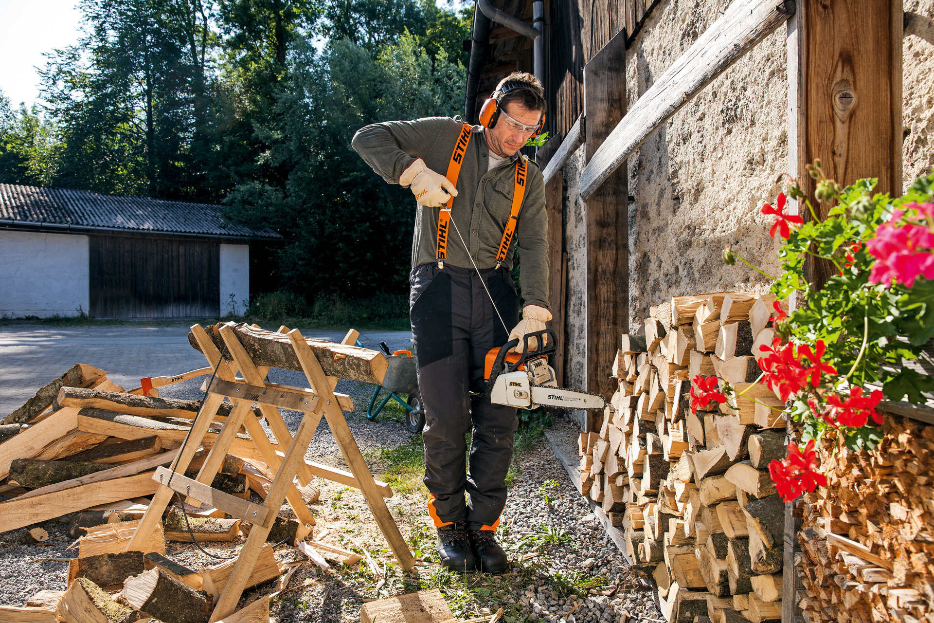 Mann in Schutzausrüstung startet STIHL Benzin-Kettensäge mit ElastoStart und Führungsschiene Light 04