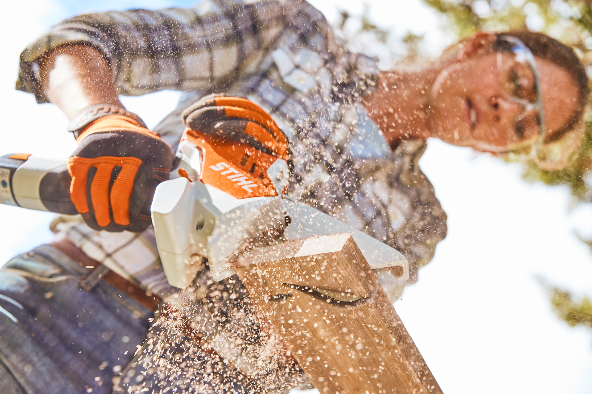 Frau sägt Holzbrett mit STIHL Säge