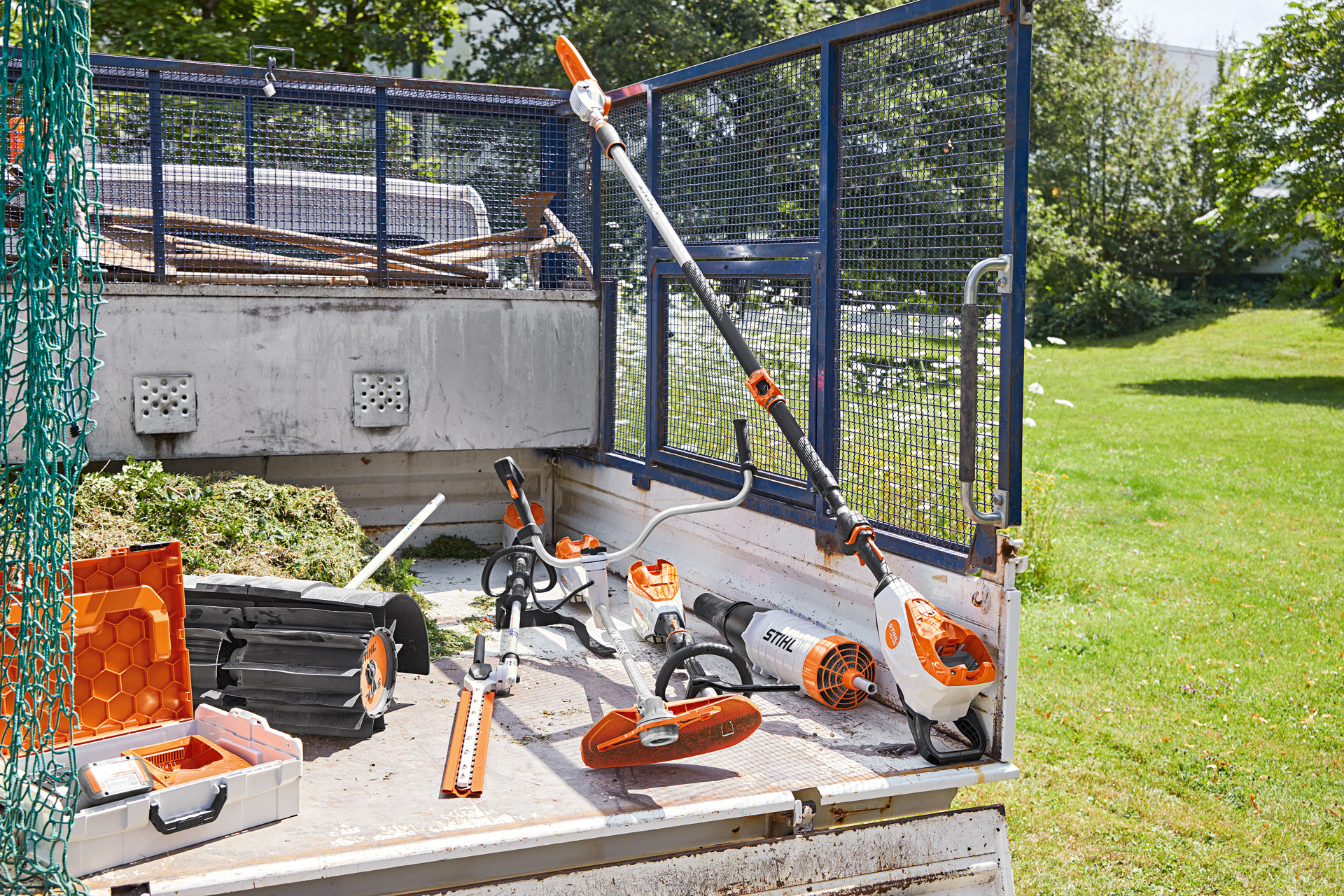 Fahrzeug mit STIHL Hochentaster HTA 135, Heckenschneider HLA 135, Motorsense FSA 135 und KMA 135 auf der Ladefläche