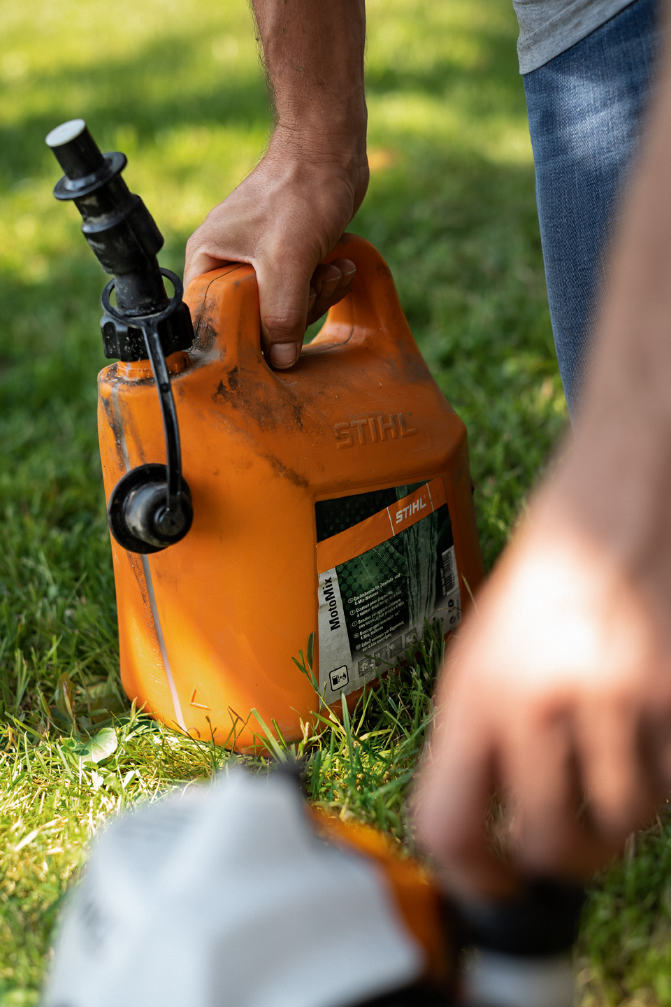 Mann hält Kanister mit Kraftstoffgemisch STIHL MotoMix 