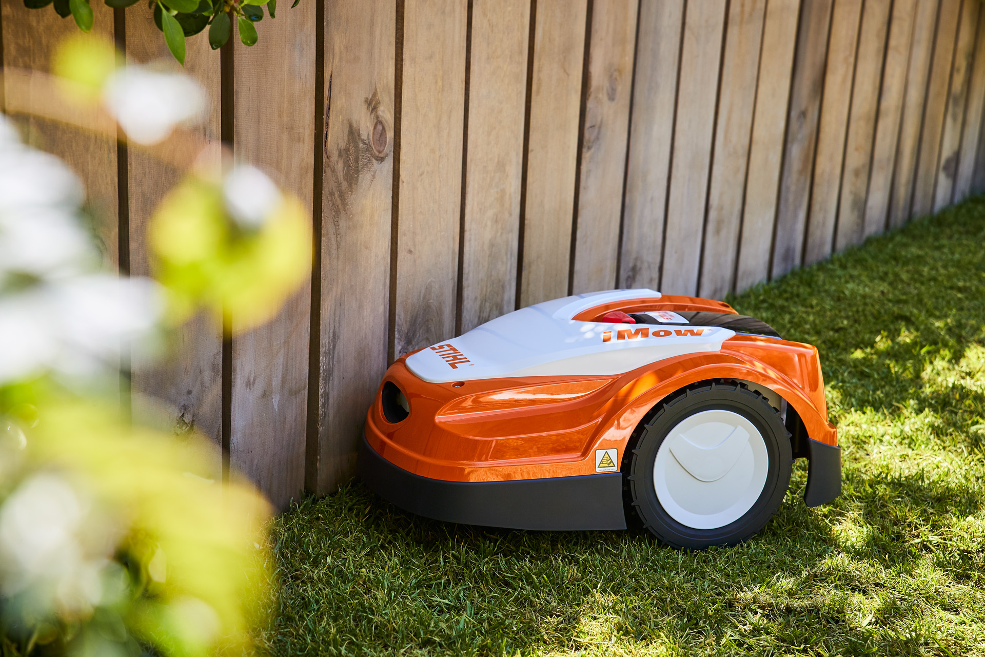 iMow® Mähroboter steht vor Gartenzaun