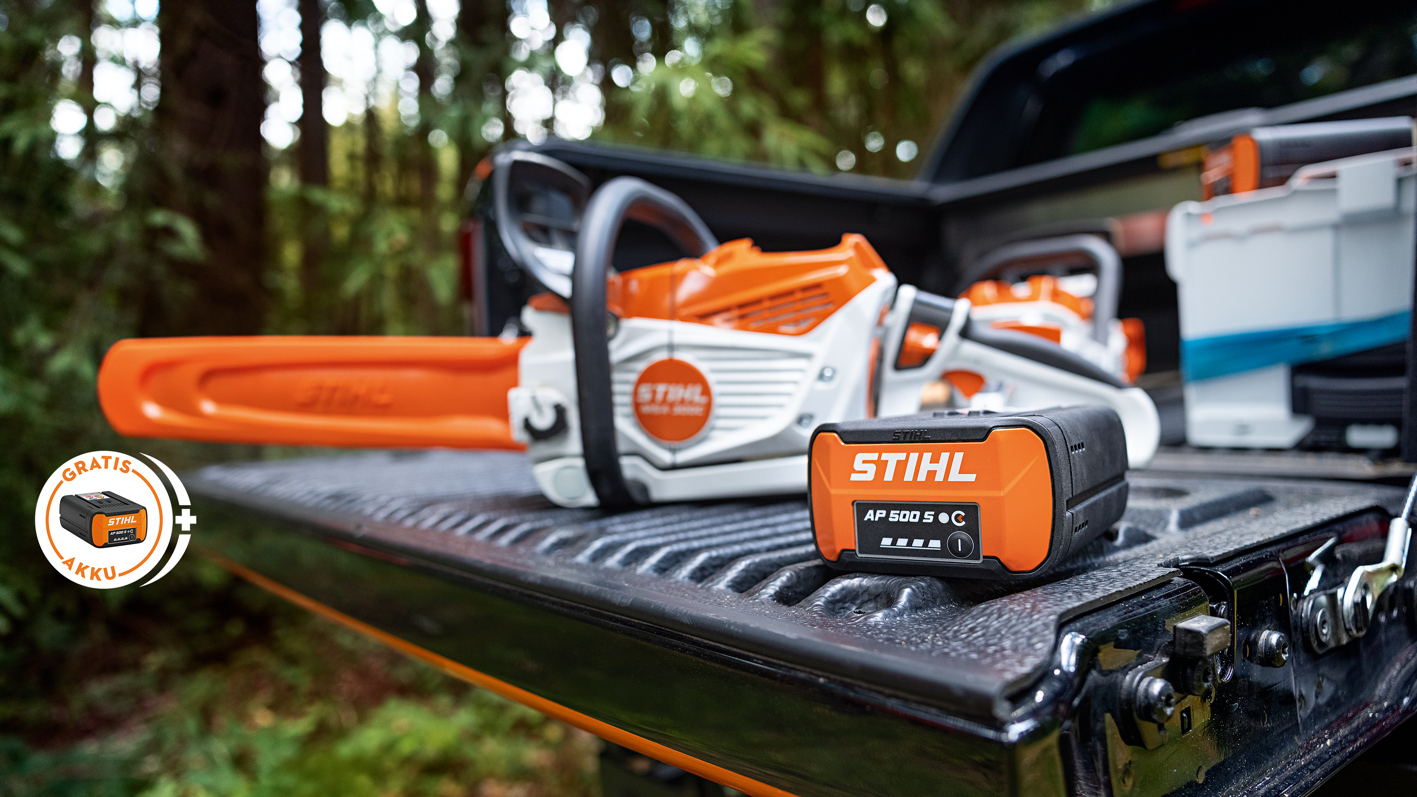 STIHL Akku AP 500 S auf der Ladefläche eines Pickups zusammen mit der neuen STIHL Akku-Motorsäge MSA 300, zusätzlich ein Hinweis-Störer mit STIHL Akku und der Aufschrift „Gratis Akku“.