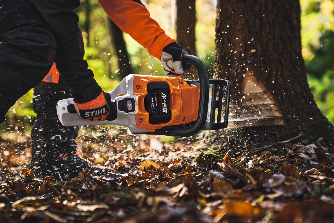 Eine professionelle Holzfachkraft fällt im Wald Bäume mit einer Akku-Kettensäge vom Typ STIHL MSA260 und einem ALLPRO-Akku